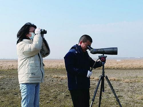 ▲邹业爱（右）和李冬梅在观察候鸟。